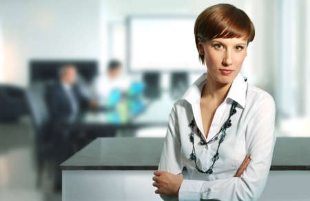 Businesswoman in a office environment, businessteam in bacground.の写真素材