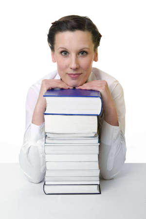 Young woman with piled up books on the deskの写真素材