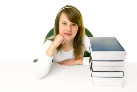 Portrait of Happy young schoolgirl smiling from behind book on a white backgroundの写真素材
