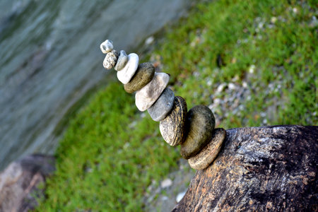 cairn the art of stone balancing on a stone near a blue water flowing river in the mountains