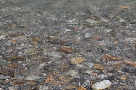 Background of water with rocks and pebbles in the river.