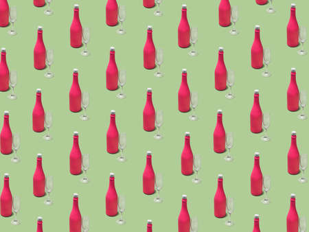 Christmas pattern made with pink champagne bottle and glass on bright light green background. Minimal Christmas party concept. Christmas isometric pattern, background, banner.の写真素材