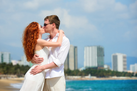 Attractive boy and girl posing and kissing on a beach の写真素材