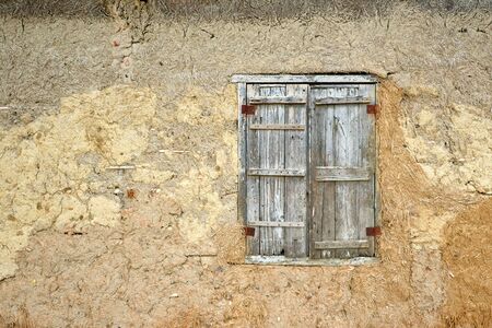 Retro window with old wooden shutters and traditional clay wall in Vietnamの写真素材