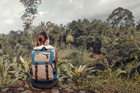 Hiker woman with backpack relax and enjoying view to rain forest .
Traveling along mountains and jungle, freedom and active lifestyle concept.の写真素材