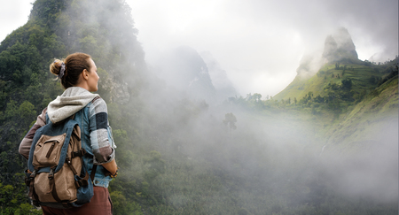 Traveler with backpack in mountains enjoying on view of foggy karst mountains North Vietnam.
Mountains and landscape, travel to Asia, happiness emotion, summer holiday conceptの写真素材