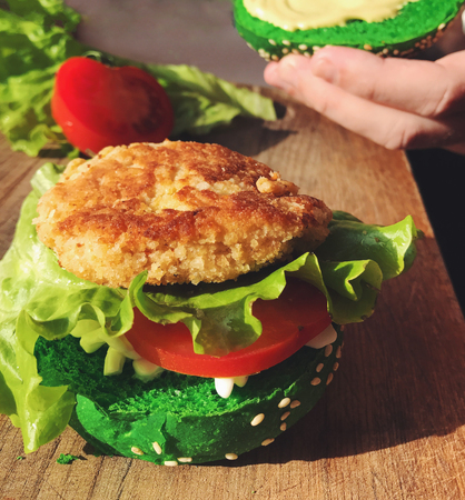 Exotic green burger in bun with sesame seeds tomato lettuceの写真素材