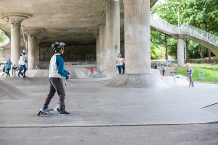 Powerful funny young guys are trained in a skate parkの写真素材