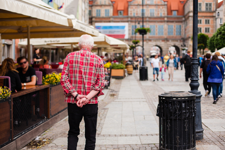 Urban life. Old lonely man goes in A Big City Streetの写真素材