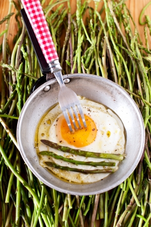 Egg in a frying pan with organic asparagusの写真素材