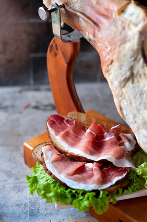 Rustic snack Prosciutto over a toasted piece of wheat bread and saladの写真素材