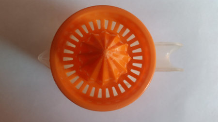 Manual juicer. Its color is orange