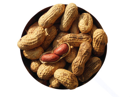 Closeup of Heap of Peanuts kept in bowl isolated on white backgroundの写真素材