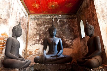 three black buddha against the ancient wallの写真素材