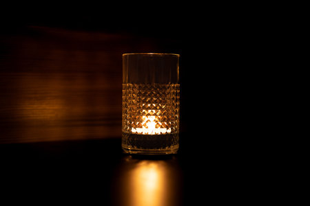 Candle in a glass. Rays of light are refracted through the walls of the glass