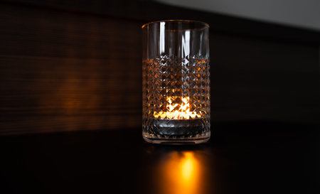 Candle in a glass. Rays of light are refracted through the walls of the glass.