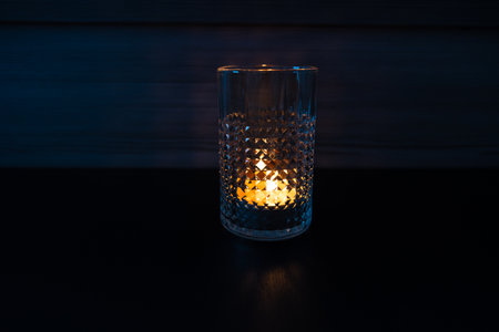 Candle in a glass. Rays of light are refracted through the walls of the glass.の写真素材