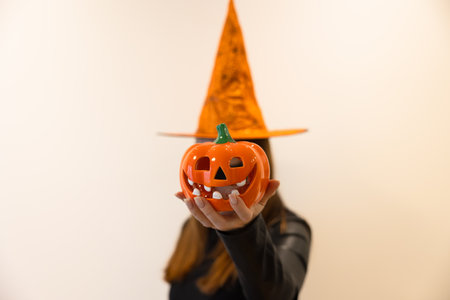 Pumpkin instead of a head. The witch holds a pumpkin in front of her face.の写真素材