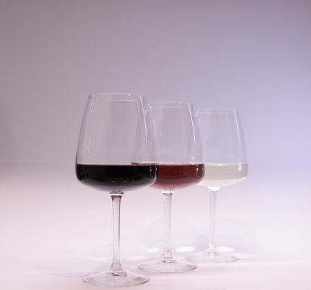 Red, white and rose wine glasses up. White backgroundの写真素材