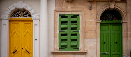 Yellow and green entrance doors in a residential building on the island of Maltaの写真素材