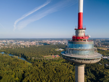 Close-up view of a telecommunications tower with an observation deck. Modern architecture and panoramic cityscape in the backgroundの写真素材