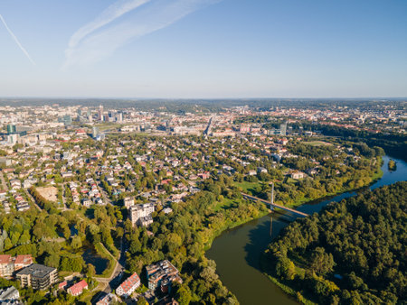 Aerial panoramic view of a city with a river and green landscapes. Urban skyline with residential and commercial buildings surrounded by natureの写真素材