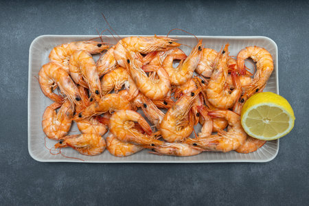 The cooked shrimp is on a platter. Lots of cooked tiger shrimp with lemon.の写真素材