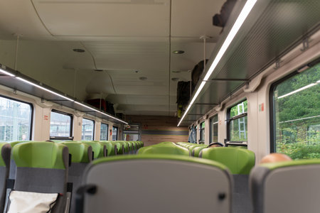 An empty cabin of a modern passenger train. Empty green seats in the passenger compartment of the...