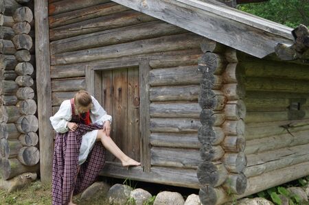 the girl from the old village, standing on a closed shed and observed the pain on his leg Russiaの写真素材