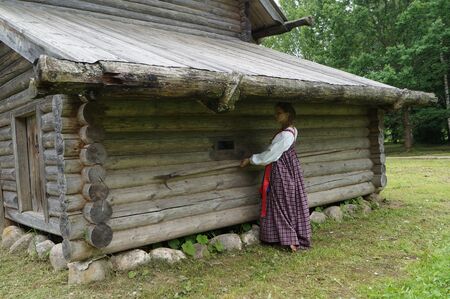 the girl in the old village,pulls out from under the roof of the shed to stick a harpoon, heavy agricultural labor in Russiaの写真素材