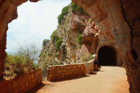 girl goes to the sea through a long tunnel in the rock, a colorful passageの写真素材