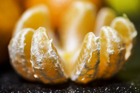 Mandarin orange fruit, peeled on a black background closeupの写真素材