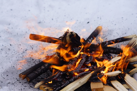 bonfire on the white snow in winter, fire and wood backgroundの写真素材