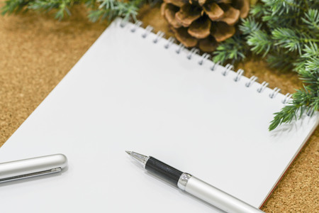 Not completed list of goals in a notebook on a wooden table with Christmas decorations and a laptopの写真素材