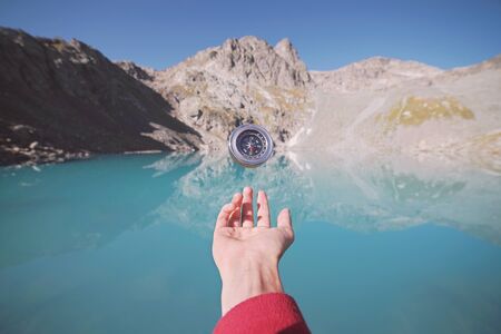 Hand with Compass with mountains background.の写真素材