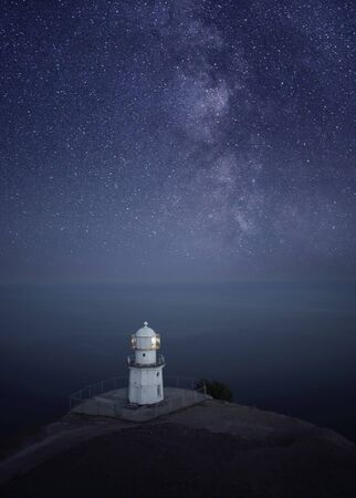 Lighthouse at night with starry sky and Milky Wayの写真素材