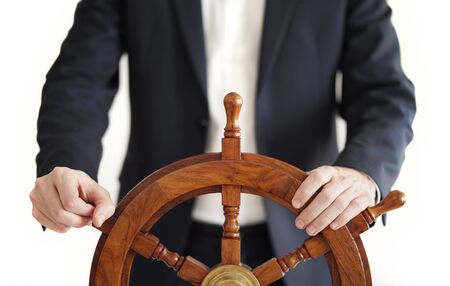 Businessman holding ship rudder.の写真素材