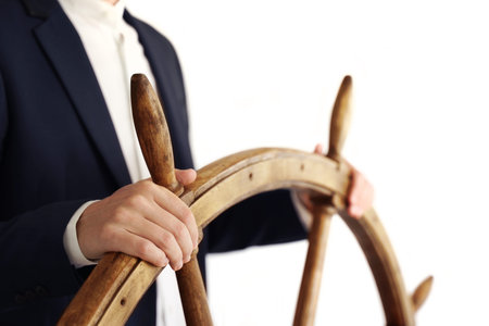 Businessman holding ship rudder.