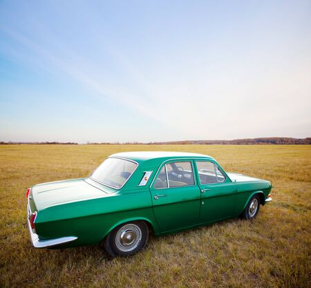Retro car in autum field. Toned image.の写真素材