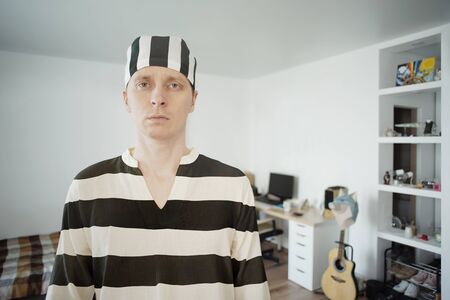 Man in Prisoner Uniform at Home. Lockdown Concept COVID-19の写真素材