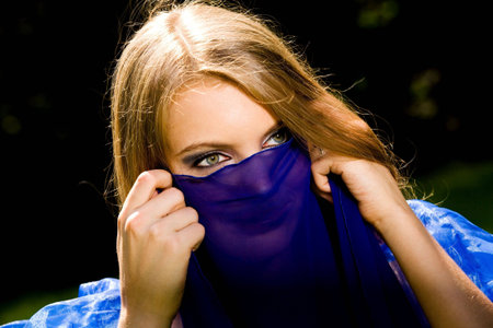 Lovely young woman dancing belly dance in blue outdoorsの写真素材