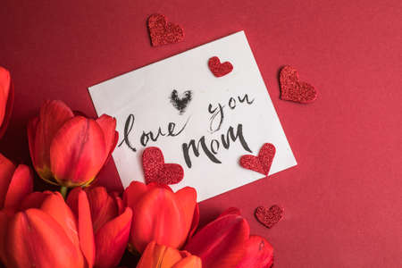 Festive floral invitation, greeting card Love you mom, background with summer spring flowers. Valentines day, mothers day, womens day, spring concept. Flat lay, top view, copy spaceの写真素材