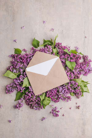 blossom Syringa vulgaris in Lilac flower and blank paper card for text message.Top view. Romantic flowers composition. Mock up frame with lilac flowers on purple backgroundの写真素材