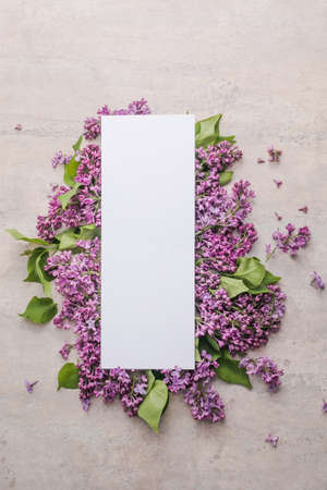 blossom Syringa vulgaris in Lilac flower and blank paper card for text message.Top view. Romantic flowers composition. Mock up frame with lilac flowers on purple backgroundの写真素材