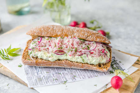 Fresh green spring sandwich with cream cheese and radish at light background. Copyspaceの写真素材