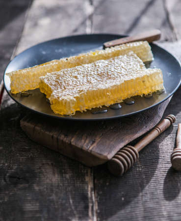 wooden honey dipper and honeycombs on background of woodenの写真素材