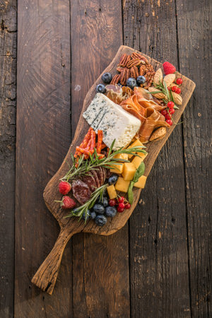 Antipasto background. Different Italian snacks with fruit, nut on a rustic background.