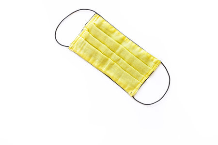Yellow medical mask to protect health from the virus on a white isolated background