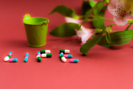 Caption life with the tablets at a red background with a tiny bucketの写真素材