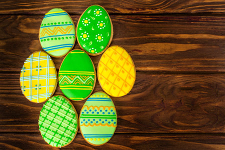 Colorful  small easter cookies on brown wooden background in a round shape
